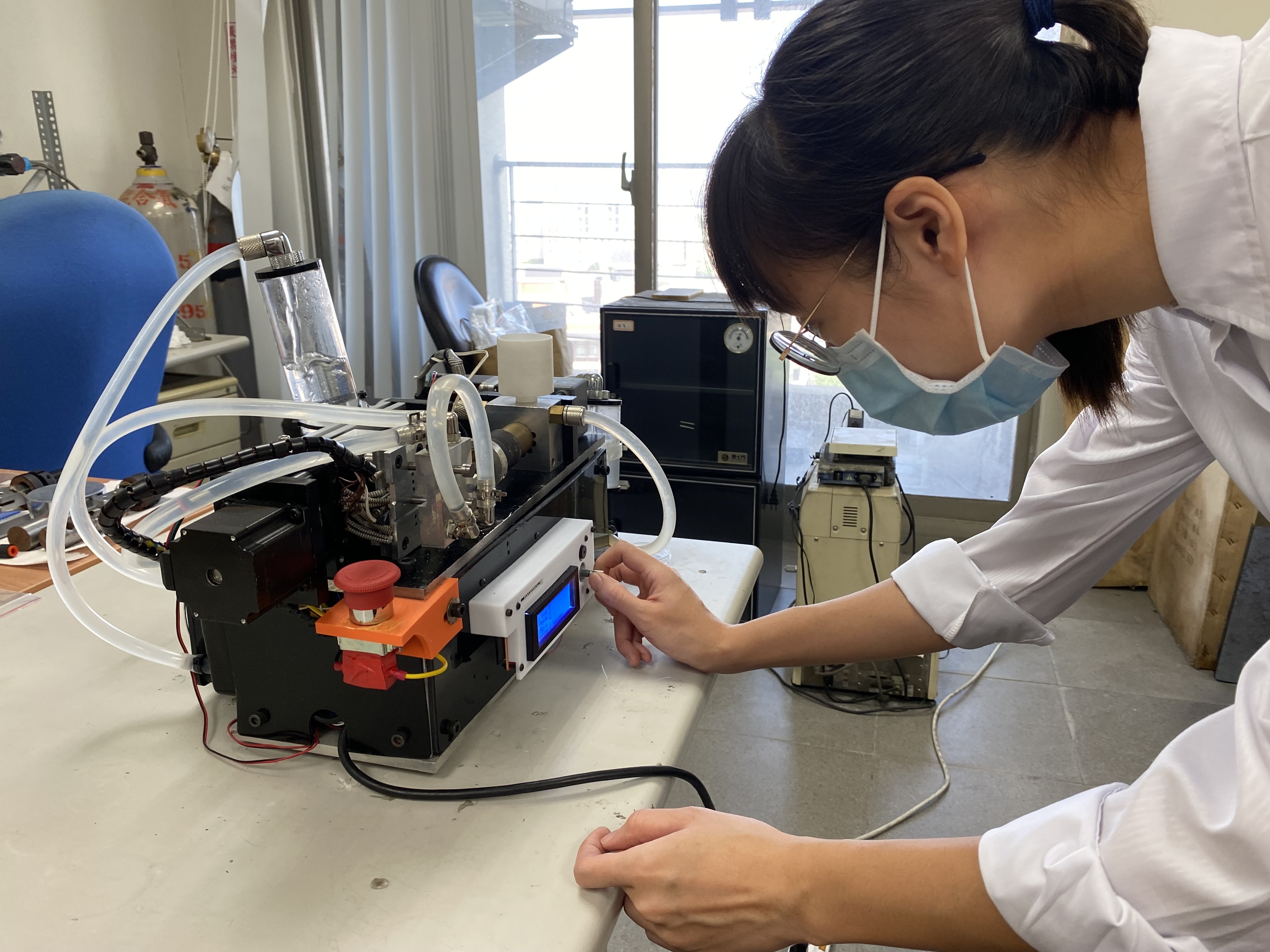 圖二:成大材料系特聘教授洪飛義團隊研發血管支架全球創新材料PLAM,圖為博士生黃嫈庭操作製作支架的精密微型射出機。