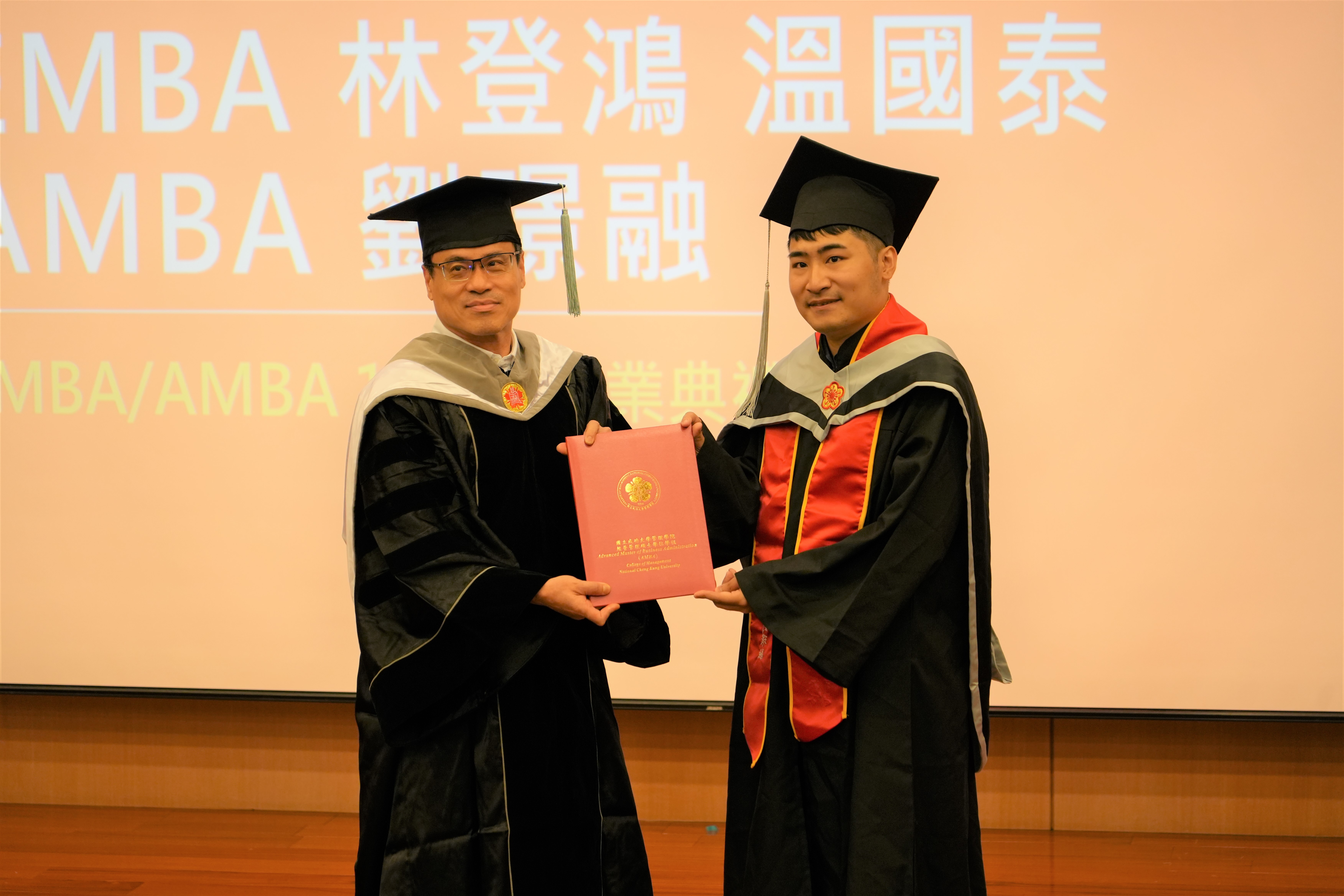 成大管理學院院長黃宇翔(圖左)頒證給AMBA畢業生代表