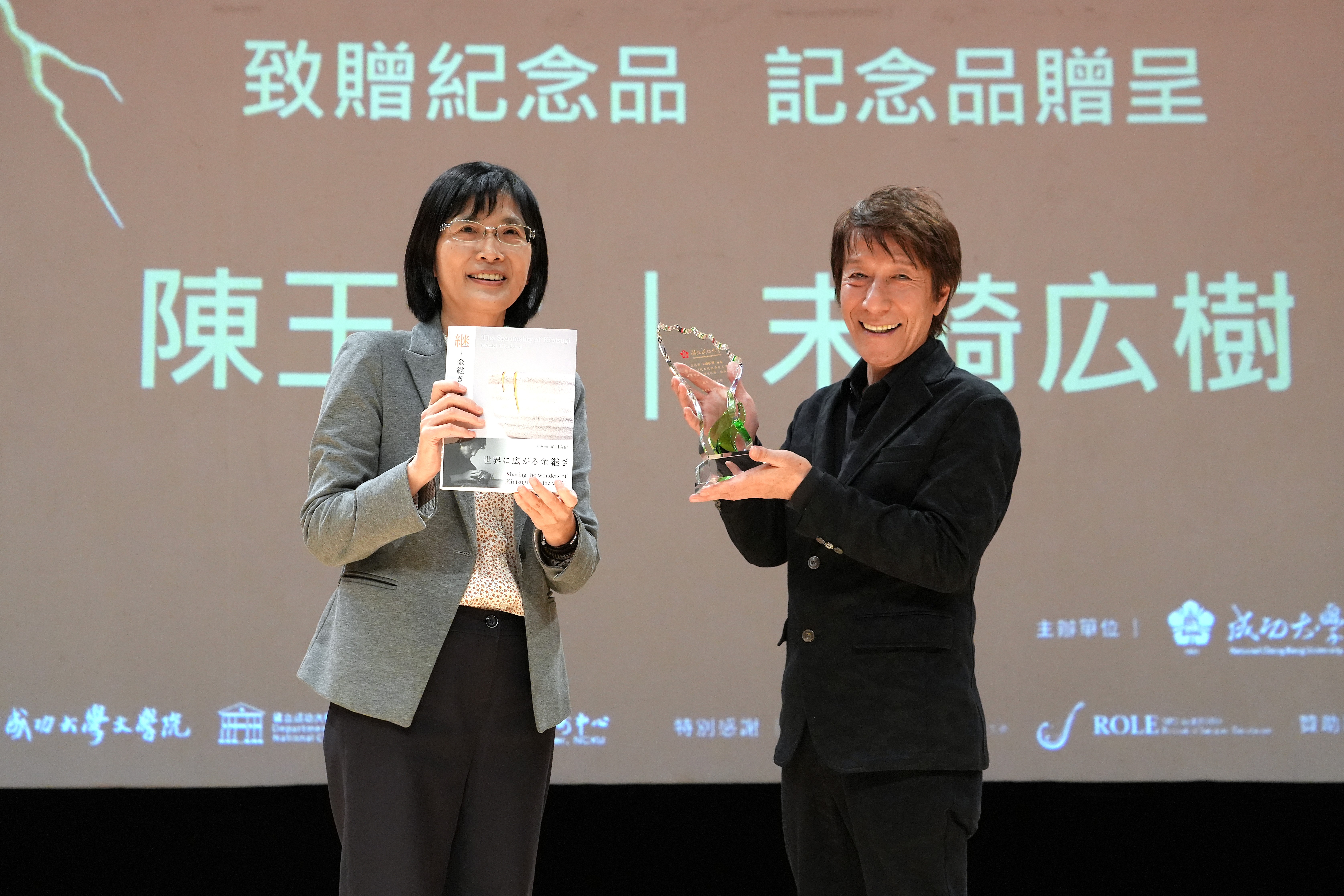 演講現場,成大副校長陳玉女(左)與日本漆藝修復大師末崎広樹(清川)互贈紀念品並合影留念