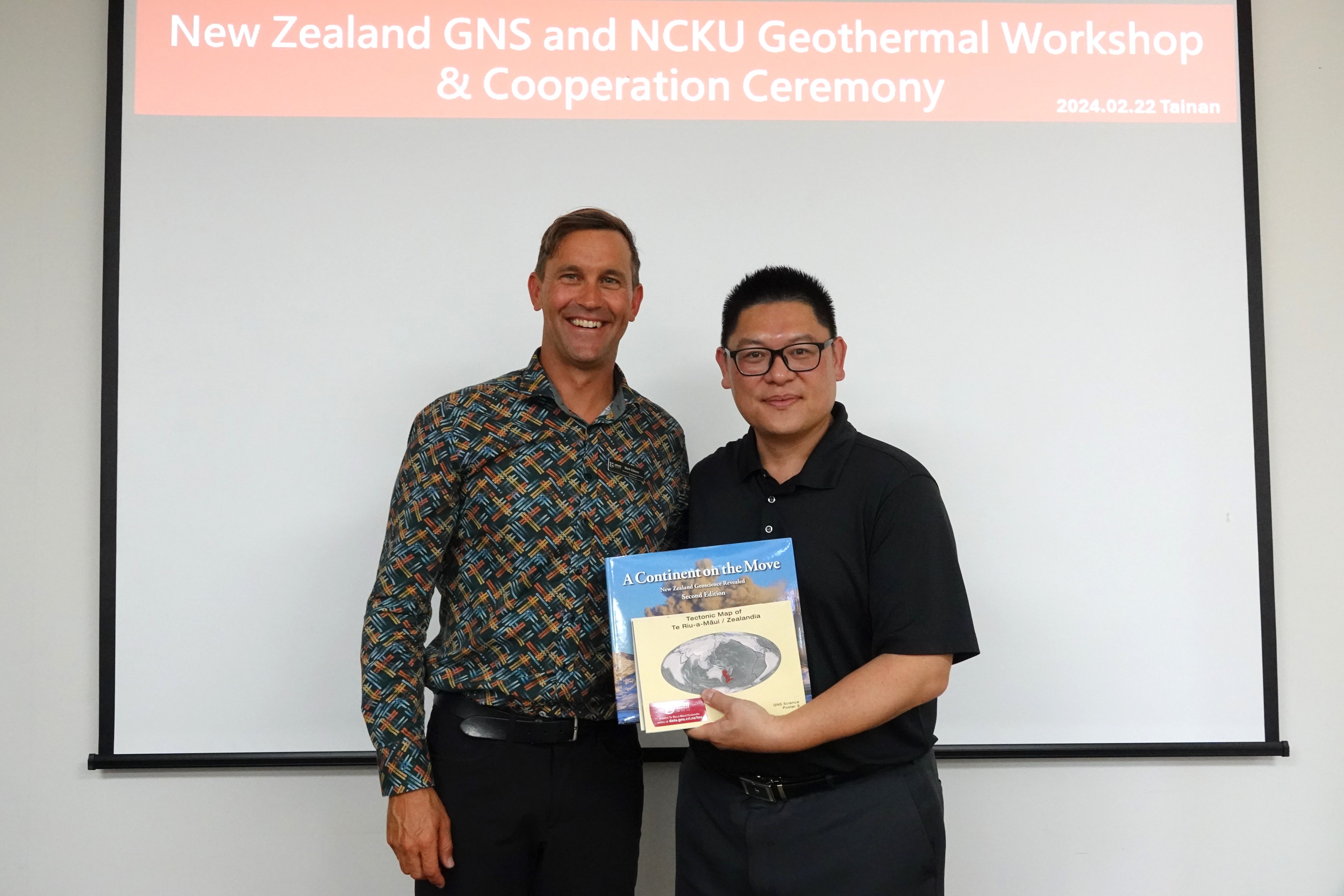 成大地熱中心主任謝秉志教授（圖右）與紐西蘭 GNS 商務經理 Mark Gibson（馬克吉布森，圖左）交換贈禮