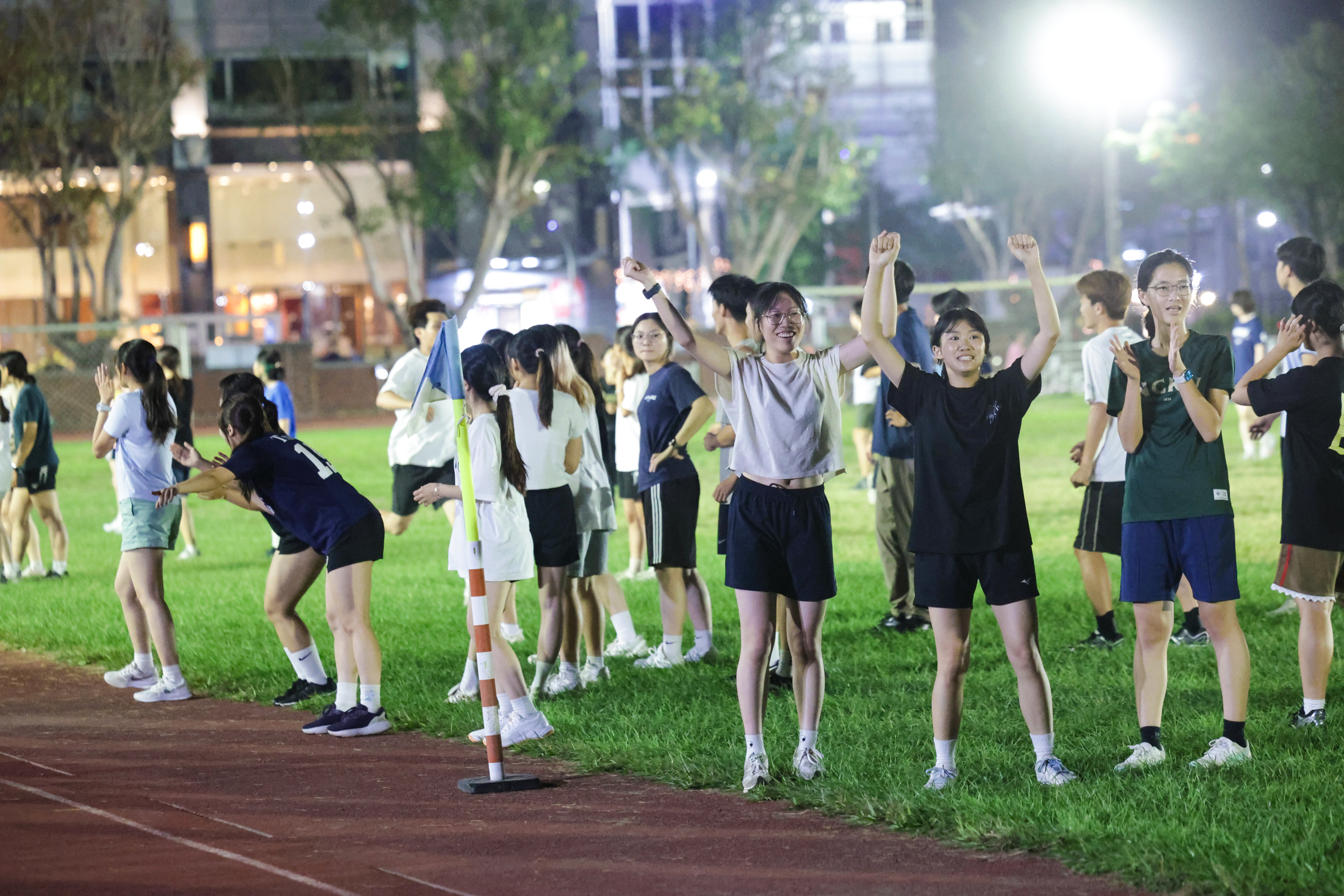 Teammates cheer enthusiastically from the sidelines, offering encouragement and support