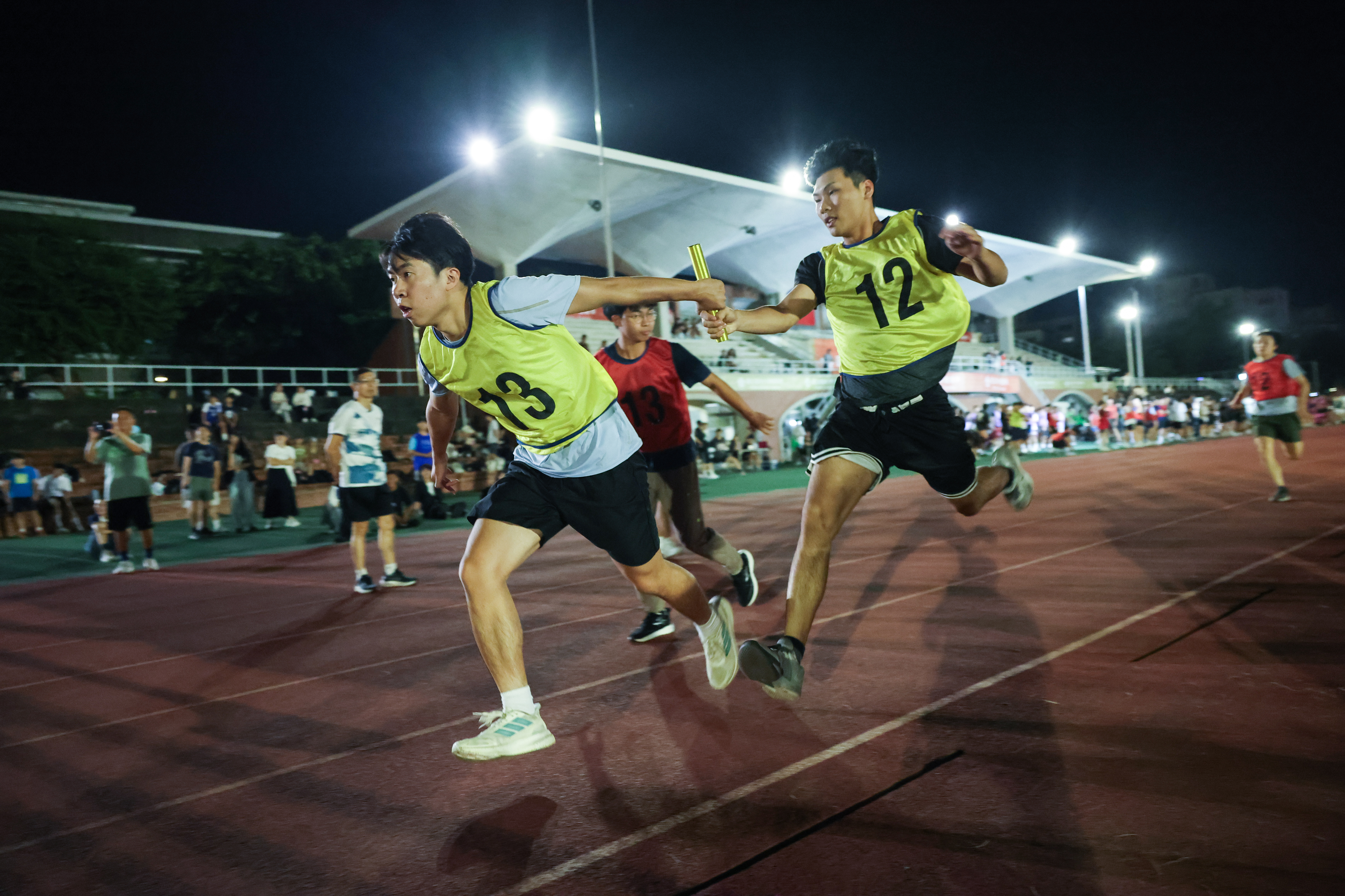 Runners sprint at full speed on the track, striving to achieve the best possible results for their teams