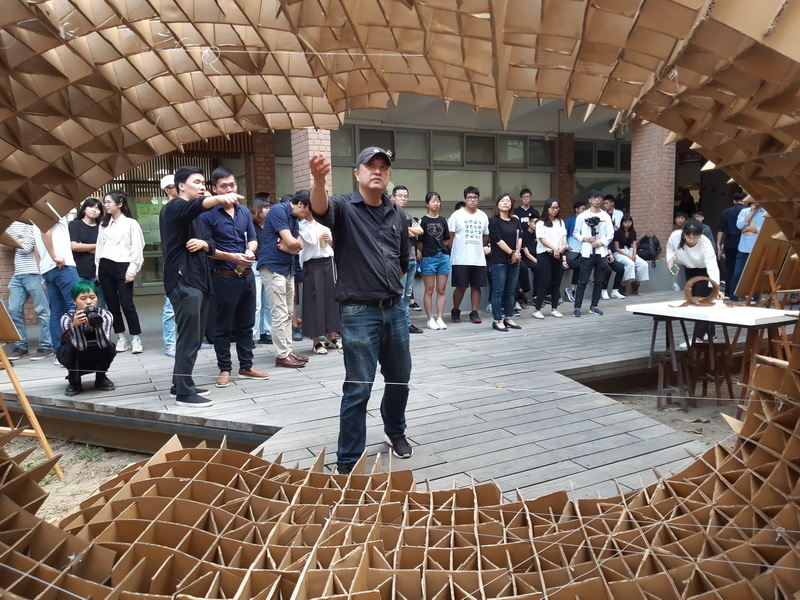 客座評圖倪順成與鄭乘騏老師跟學生們在紙構築作品前互動