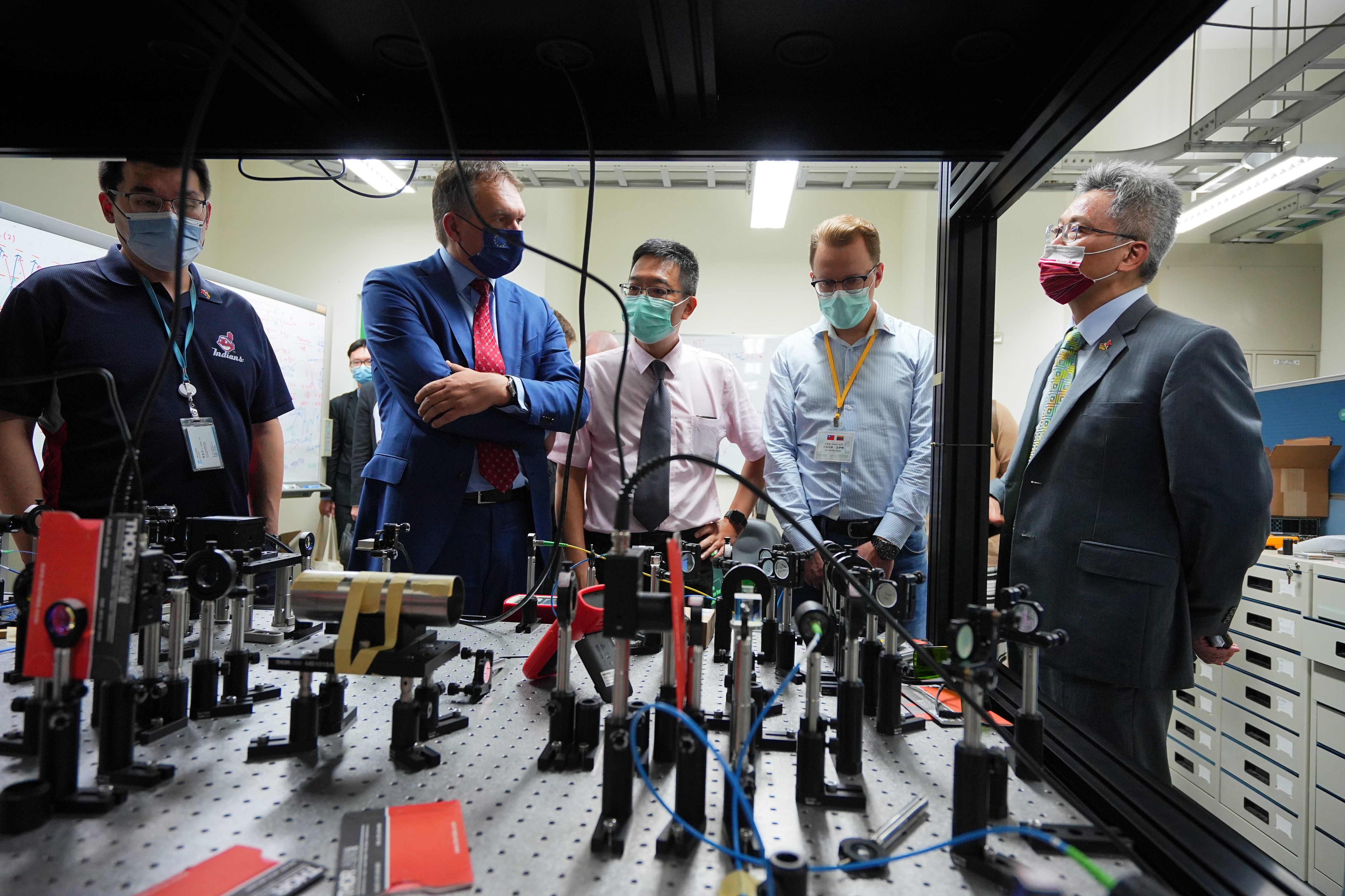 Chin-Chun Tsai, Dean of the College of Science, demonstrates the equipment in the college's laboratory to Lithuanian representative Paulius Lukauskas (second left).