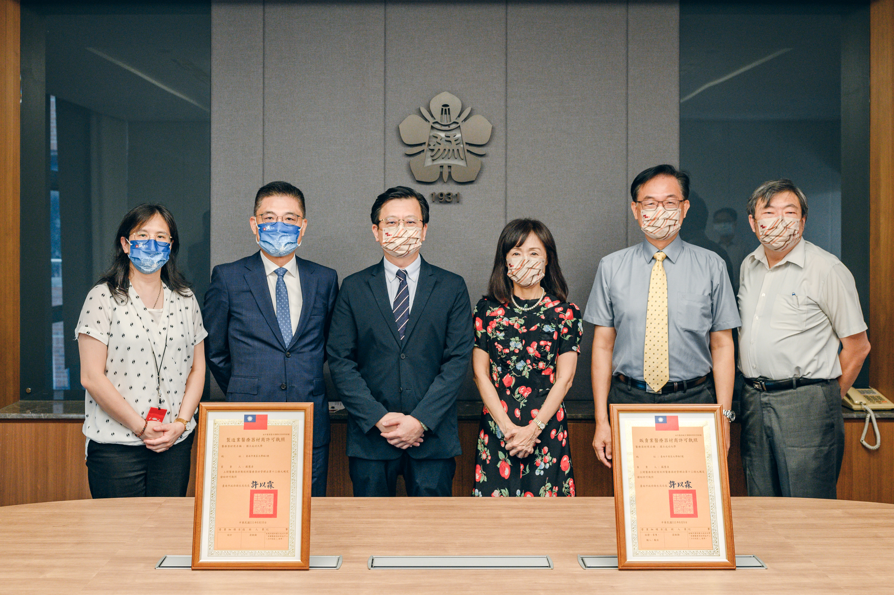 台南市衛生局長（左）許以霖頒贈許可證，由成大校長蘇慧貞（右）代表接受