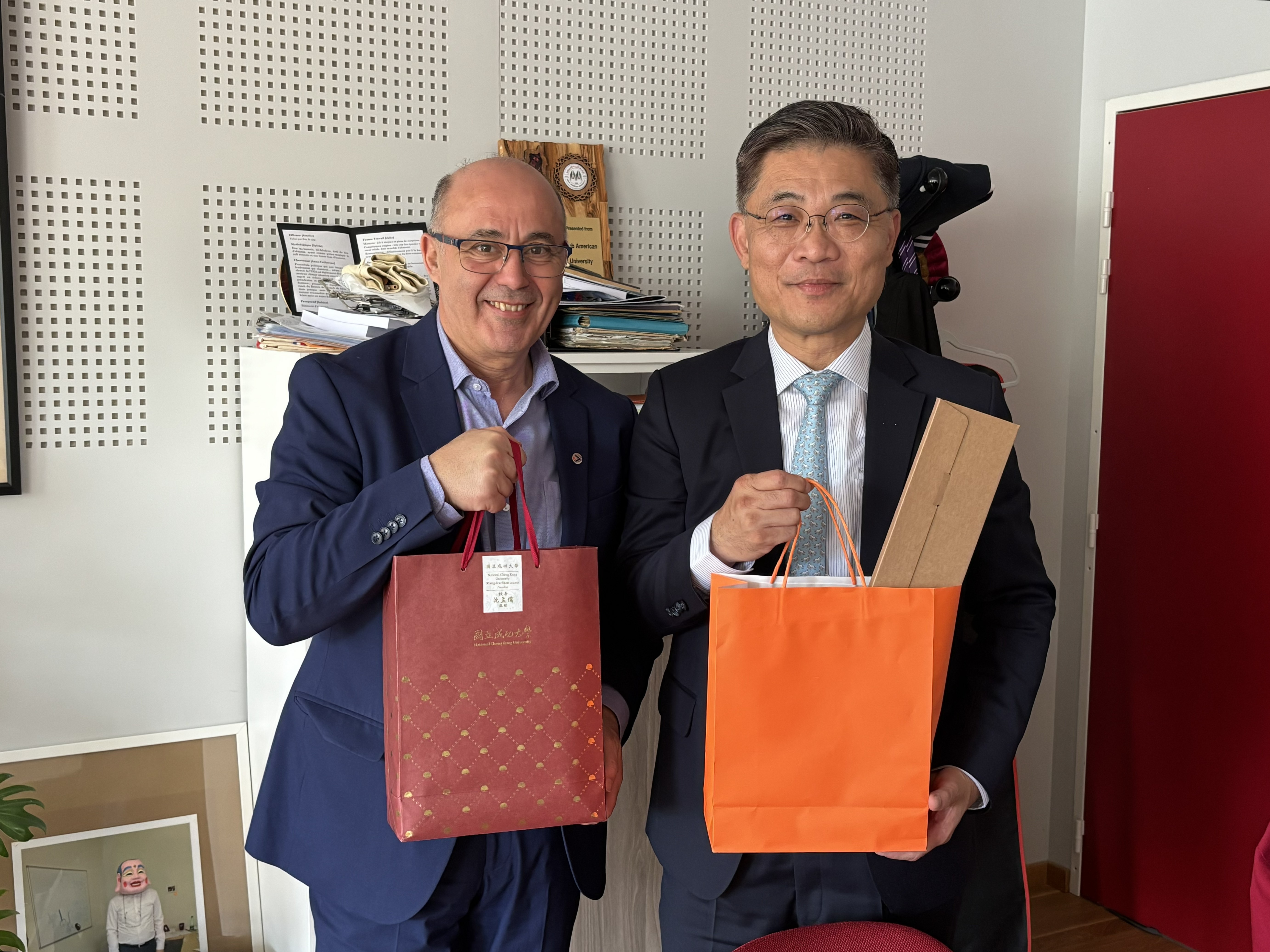 Professor Yassine Lakhnech (left), rector of Grenoble Alpes University, and President Shen Mengru exchange gifts and pose for a photo.