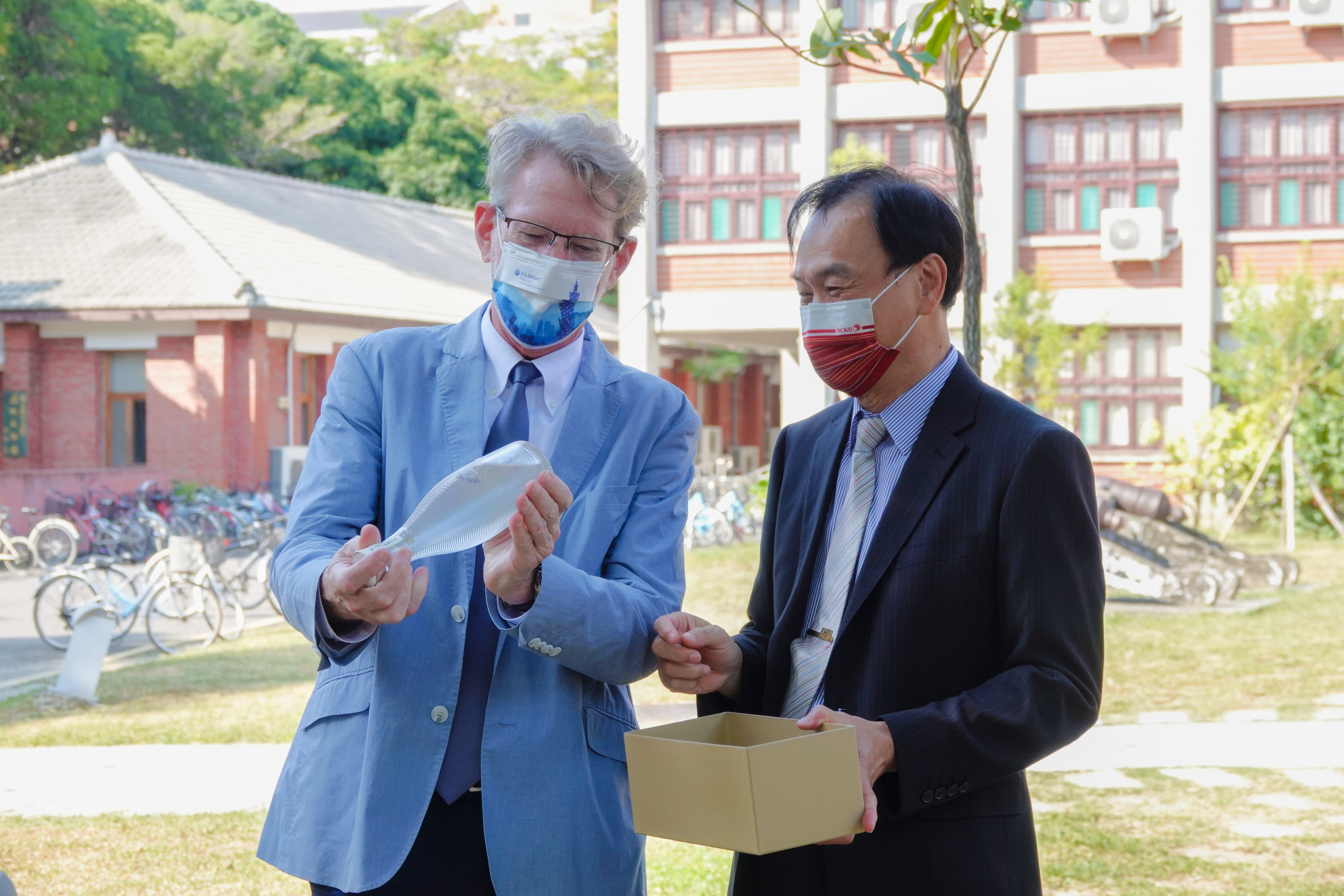 NCKU's Executive Vice President Fong-Chin Su (the right) presented the FSE Executive Director Dr. Nadeau with the NCKU 90th Anniversary Matsu Kaoliang Liquor.