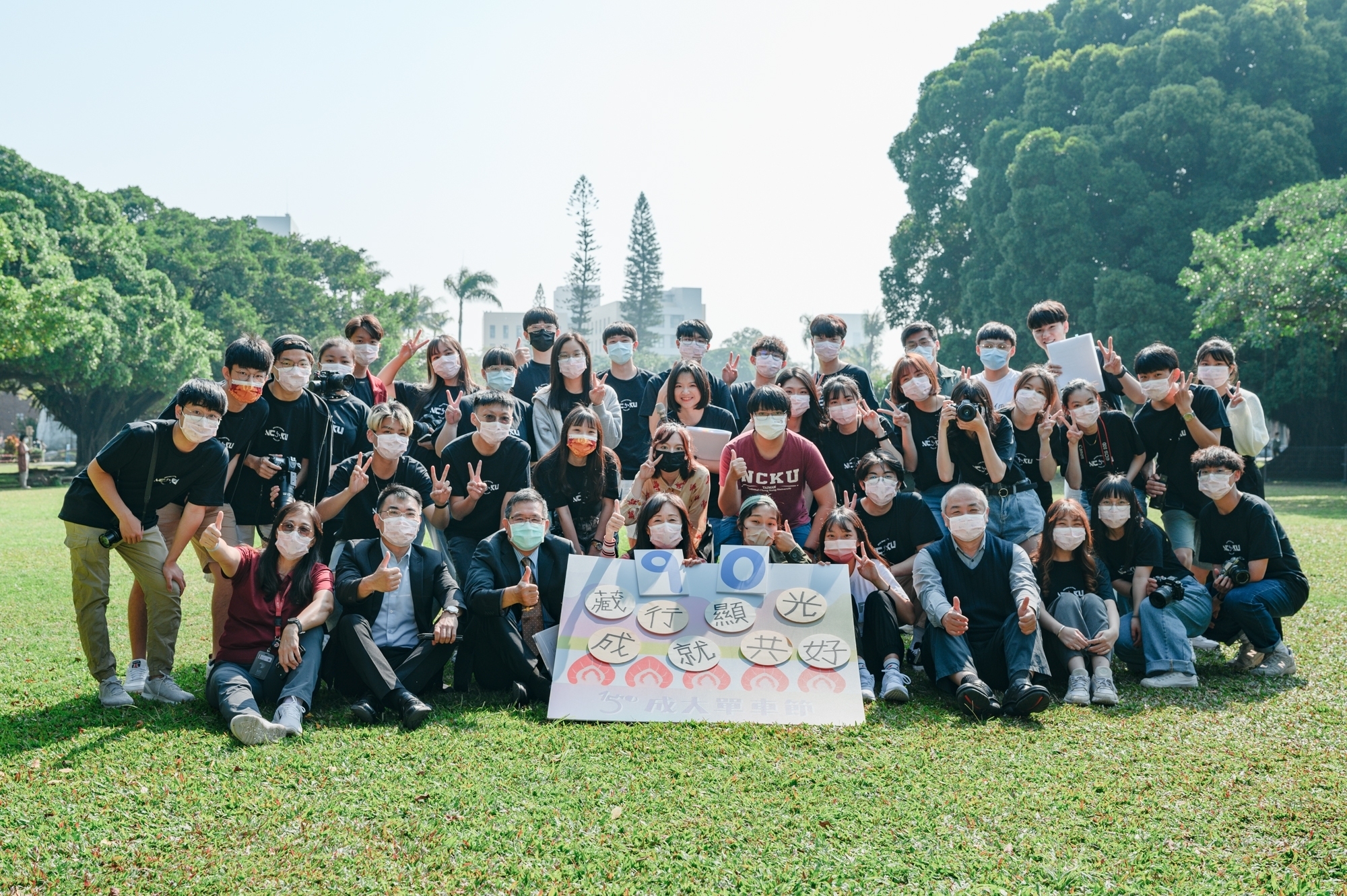 第 15 屆成大單車節開幕貴賓與單車節學生團隊在榕園的草皮上合影