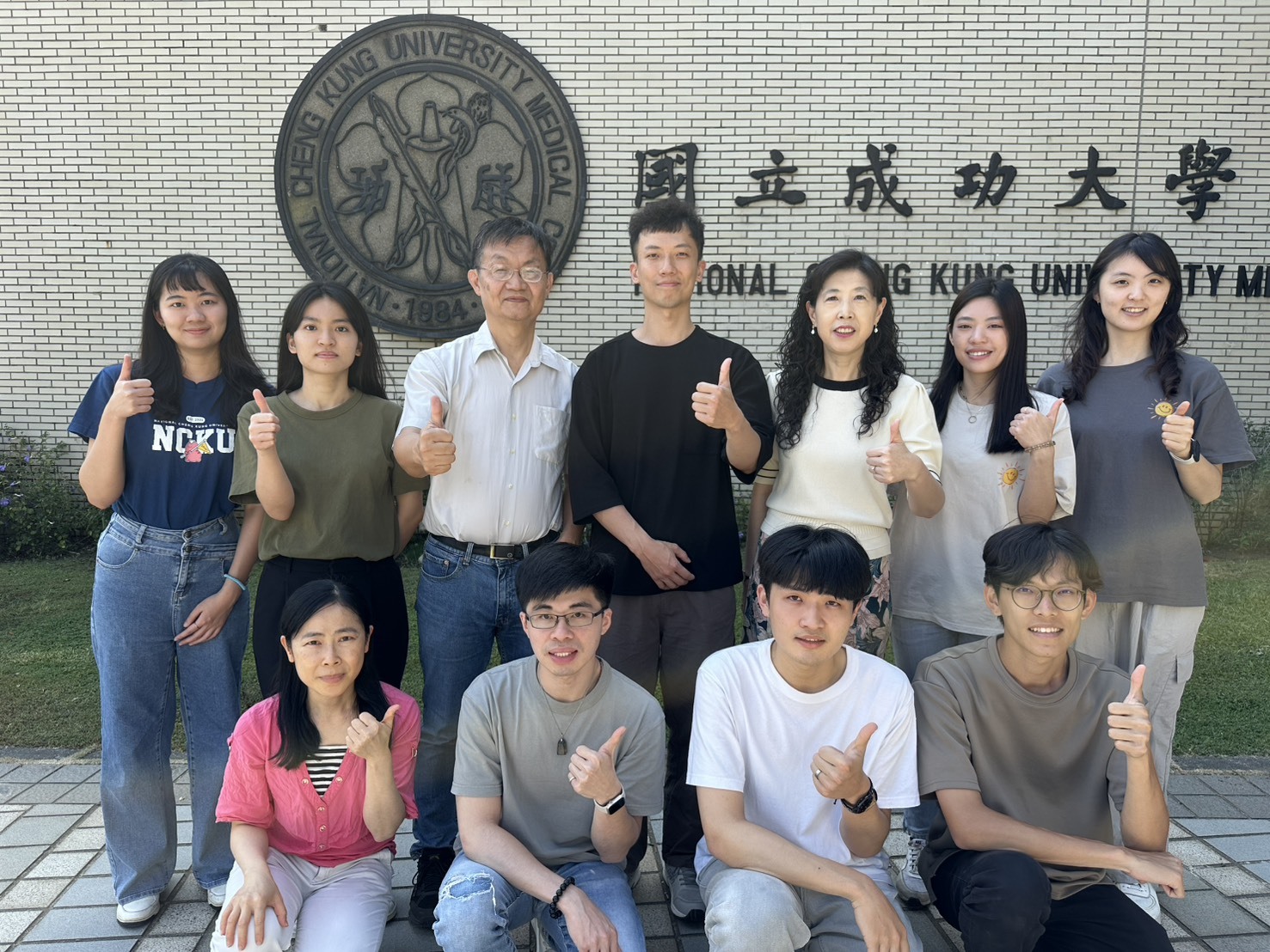 圖二：成大藥理學研究所所長王憶卿講座教授（後排右3）與生物科技與產業科學系洪建中特聘教授（後排左3）團隊