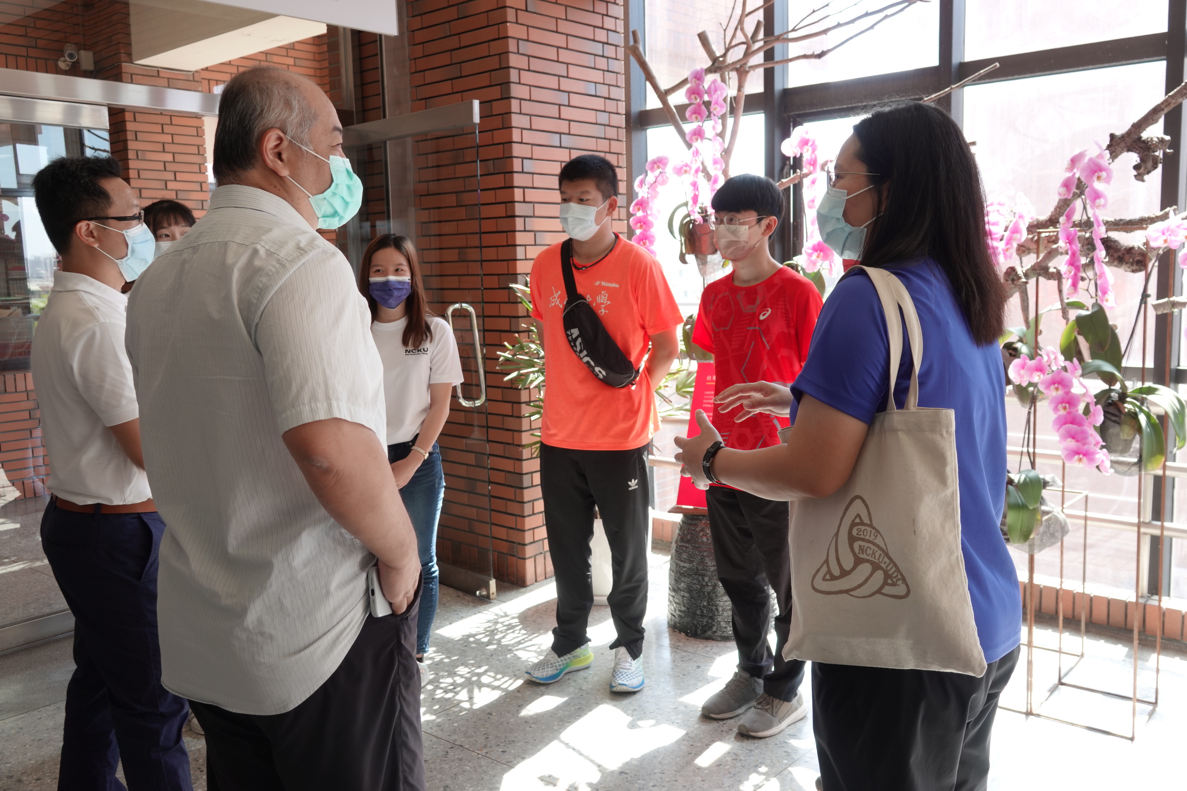 體育室主任黃賢哲(左1)與教務長王育民(左2)向運動員加油打氣