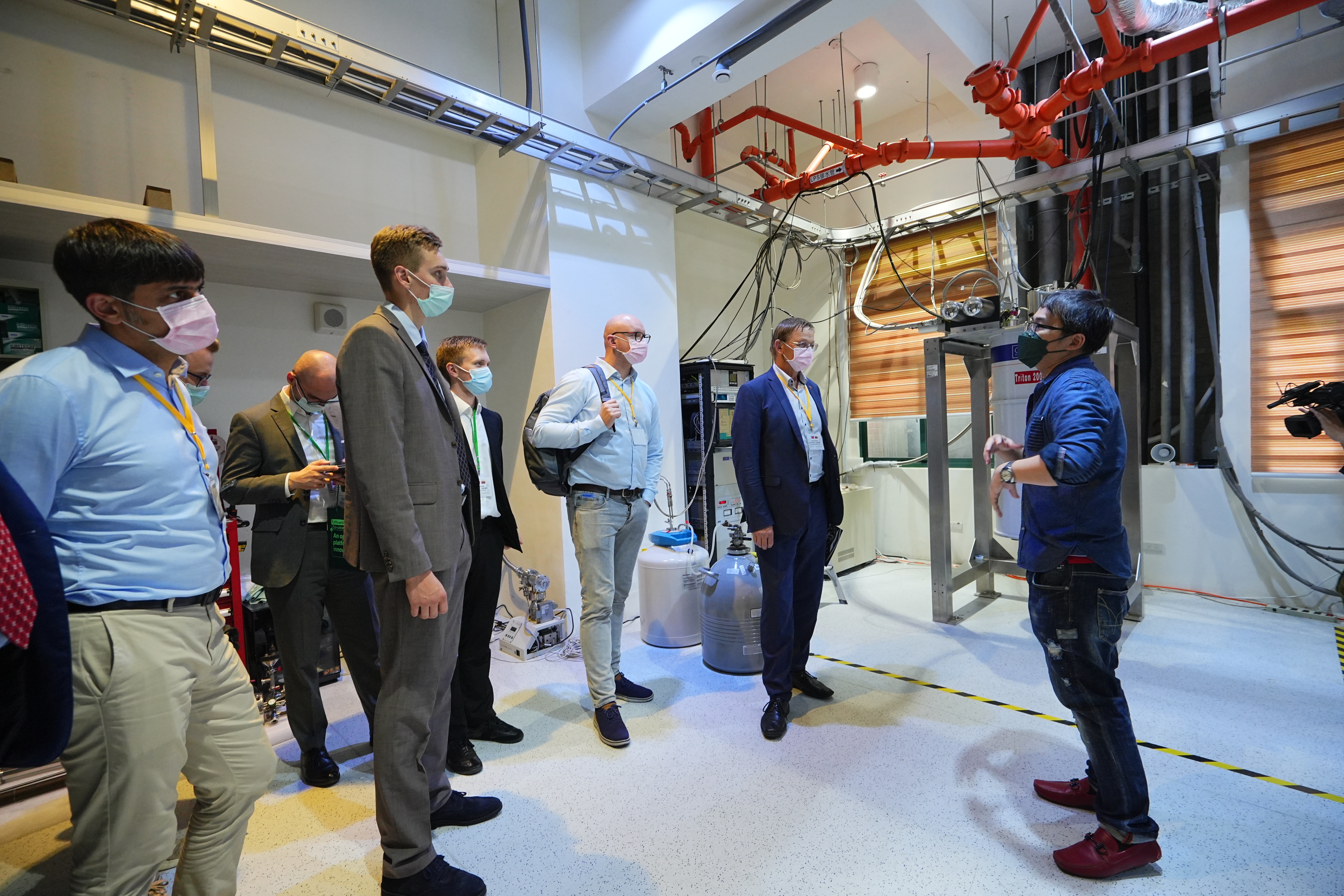 Tse-Ming Chen, professor at the Department of Physics in NCKU, introduces the equipment to the delegation members.