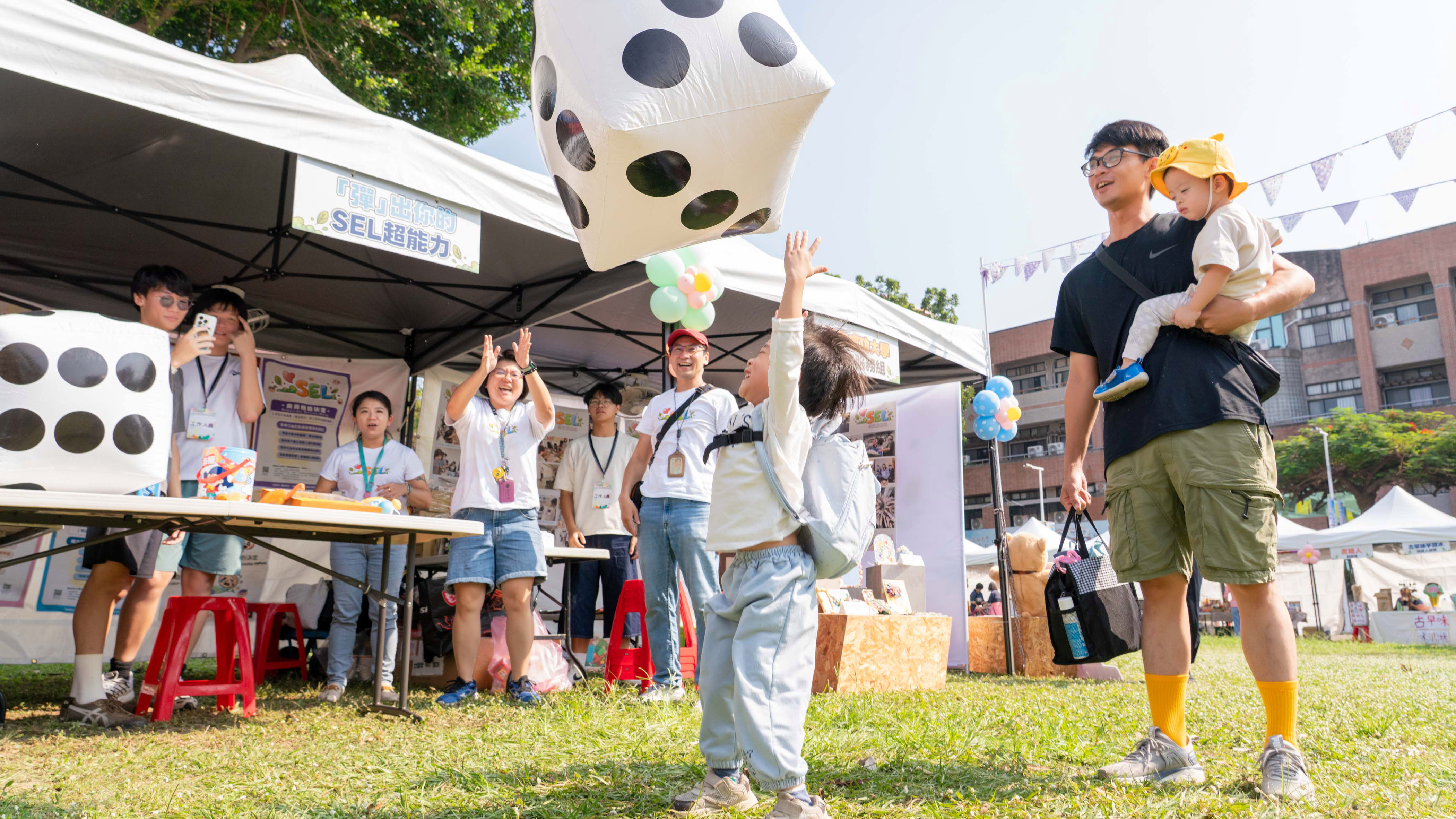 家長帶著孩子熱情參與特色展攤互動,在歡樂遊戲中學習情緒覺察